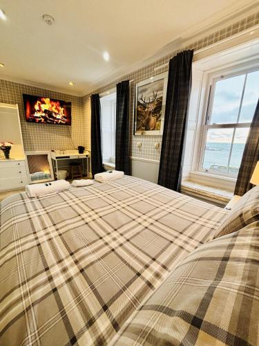 ein Schlafzimmer mit einem großen Bett und einem großen Fenster in der Unterkunft The Waterfront in Portpatrick
