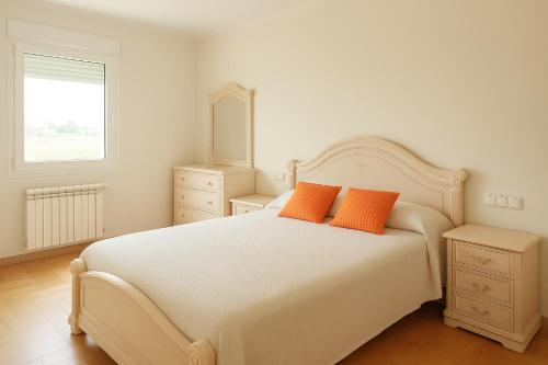 MarinaMar Camariñas في كامارينياس: غرفة نوم بسرير ابيض مع وسادتين برتقاليتين