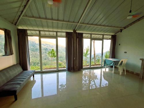 a room with a couch and a table and windows at Hacienda & Reserva Monterrico in Romilda