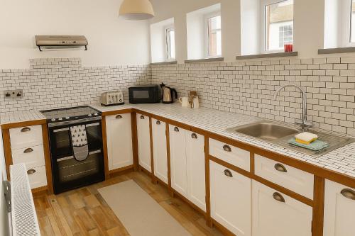 a kitchen with a sink and a stove at High Living in Carlisle