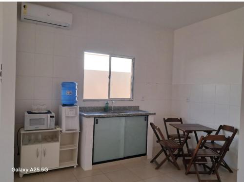 Enjoy Canastra في ديلفينوبوليس: مطبخ مع حوض وطاولة وكراسي