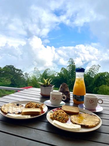 a table with two plates of food and a bottle of orange juice at MINI-SUiTE CONFORT in Estación El Salto