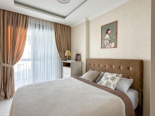 a bedroom with a large bed and a window at Апартаменты Qoople Triumph 17 рядом с пляжем Клеопатры in Alanya