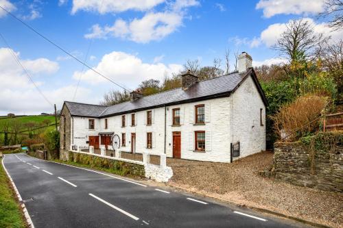 a white house on the side of a road at The Old Bakehouse - Group Getaway in Llandysul