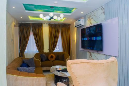 a living room with a couch and a flat screen tv at Gpark Luxury Homes And Apartments in Sagamu