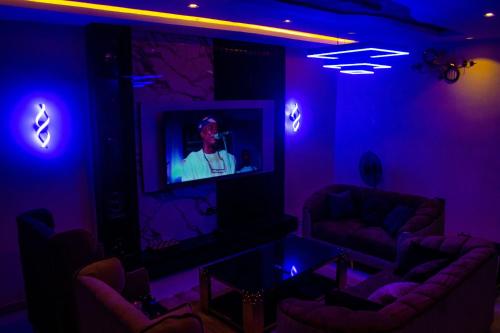 a living room with purple lights and a tv at Gpark Luxury Homes And Apartments in Sagamu
