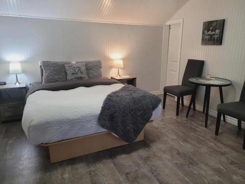 a bedroom with a bed and two chairs and a table at Bed and Breakfast Du Repos in Saint Quentin