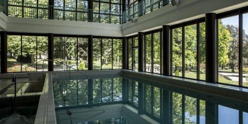 a large house with a swimming pool and windows at Chalet Cocoon en lisière de forêt, avec grande terrasse, et vue 'waouh' in Allevard