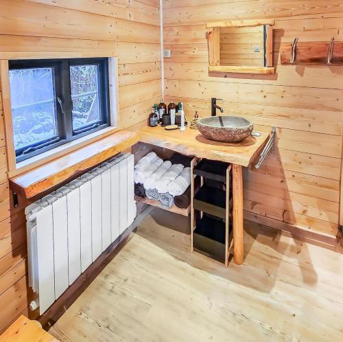 a bathroom with a sink in a log cabin at Chalet Cocoon en lisière de forêt, avec grande terrasse, et vue 'waouh' in Allevard