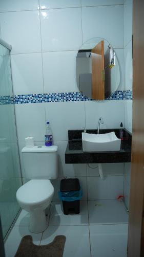 a bathroom with a white toilet and a sink at Casa Bosque da Serra in Crato