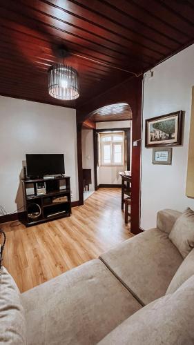 a living room with a couch and a flat screen tv at Casa do Pelourinho in Coja