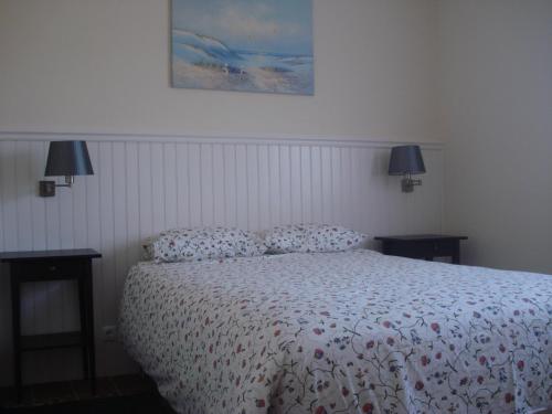 a bedroom with a bed and two tables with lamps at Casa Agricola Quinta Da Junqueira in Reguengo Grande