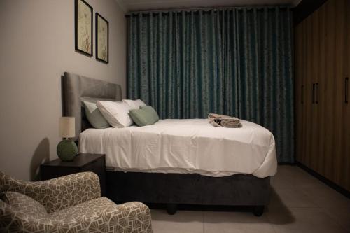 Serene Retreat في ميدراند: غرفة نوم بها سرير وكرسي