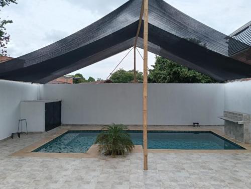 a swimming pool with a black canopy over it at Casa familiar con piscina privada in Agua de Dios
