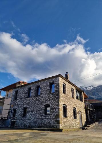 a large brick building with a blue sky and clouds at Vasiliki Pramanta villas in Pramanta