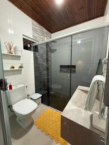 a bathroom with a toilet and a glass shower at Cantinho Santiago in Alto Paraíso de Goiás