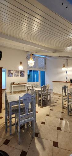 a dining room with wooden tables and chairs at Pousada Quintal da Praça in Prado