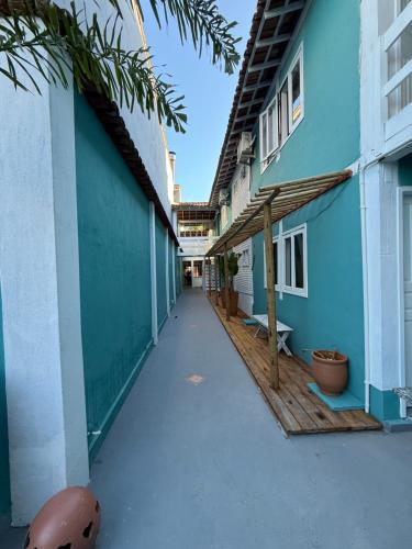 a walkway between two buildings with blue walls at Pousada Quintal da Praça in Prado