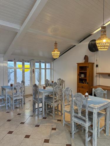 a dining room with tables and chairs and windows at Pousada Quintal da Praça in Prado