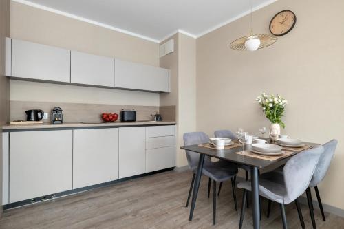 a kitchen and dining room with a table and chairs at BelMare Aqua Resort by Solarento in Międzyzdroje