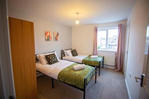 een kleine kamer met twee bedden en een raam bij Long Barn House - Andover in Enham-Alamein