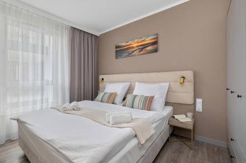 a bedroom with a large bed with white sheets at BelMare Aqua Resort by Solarento in Międzyzdroje