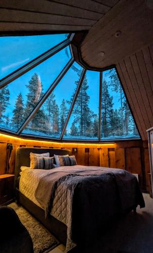 a bed in a room with a large window at North Frontier Cabins in Saariselka