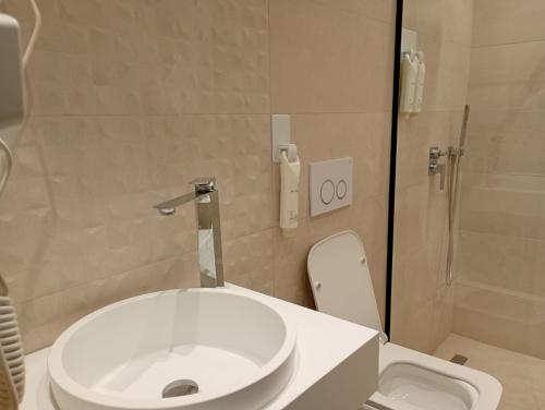 a bathroom with a white toilet and a shower at City Urban Hotel in Tirana