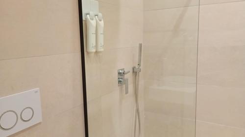 una ducha en un baño con puerta de cristal en City Urban Hotel, en Tirana