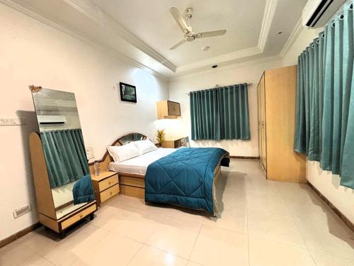 a bedroom with a bed with a blue blanket at Tranquil Trails-Sharvari Villa-Nashik in Nashik