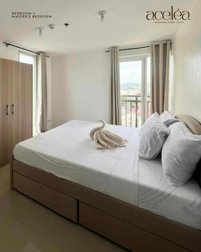 una camera da letto con un grande letto bianco con una finestra di Bernwood Tower 2BR-707 a Città di Iloilo