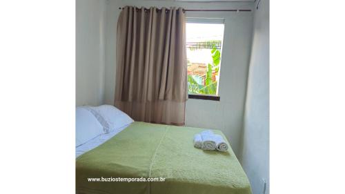 a bedroom with a bed with two towels on it at Pé na areia Geriba Buzios 2 in Búzios