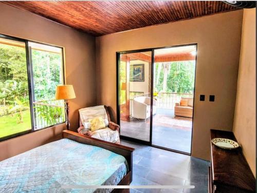 a bedroom with a bed and a view of a yard at Paseo de Damitas in Quepos