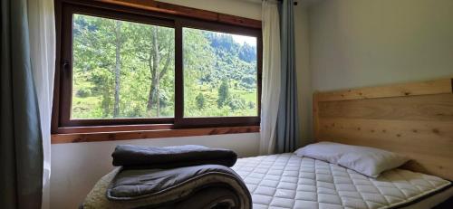 a bedroom with a bed in front of a window at Casa campo en plena naturaleza 3 dormitorios y 2 baños in Lago Ranco