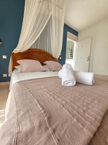 a large bed with a white stuffed animal on it at GîTE MAYO & HYLODES'S SONG in Bouillante