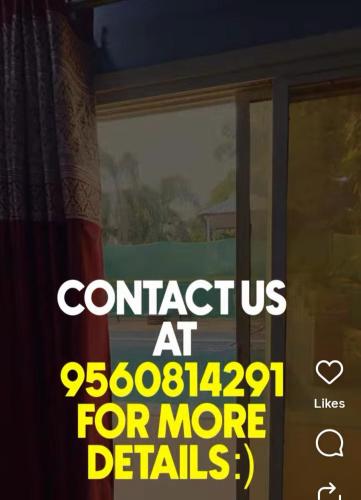 诺伊达DM Farmhouse的窗户上贴着一张告示，上面写着：联系我们了解更多信息。