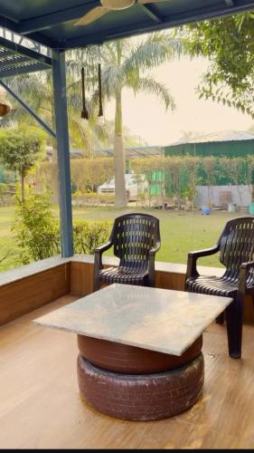 诺伊达DM Farmhouse的一张桌子、两把椅子和一张桌子