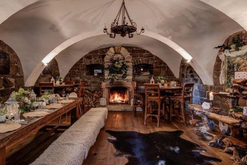 a large room with a fireplace and a dining room with tables at Silverstone Living in Semily