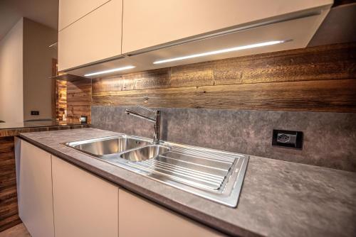 una cocina con fregadero y encimera en Bait da Nicolin - Myholidaylivigno, en Livigno