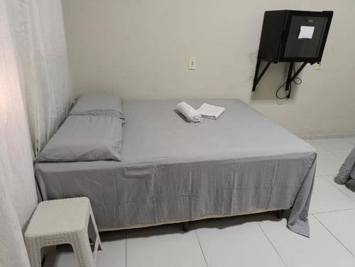 a bed in a room with a tv and a bed sidx sidx sidx at Pousada Cajueiro in Juazeiro do Norte