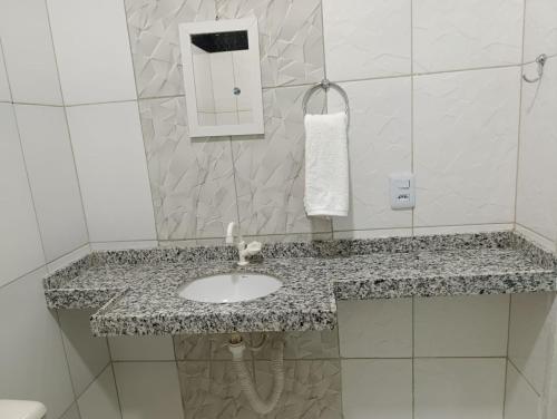 a bathroom with a sink and a mirror at Pousada Cajueiro in Juazeiro do Norte