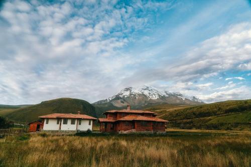 a house in a field with a mountain in the background at Taytapak Wasi in Riobamba