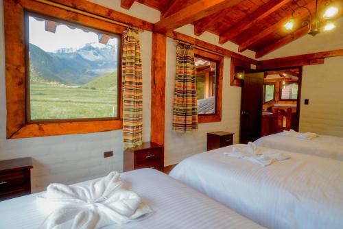 a bedroom with two beds and a large window at Taytapak Wasi in Riobamba