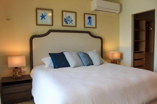 een slaapkamer met een groot wit bed met blauwe kussens bij Creta Luxury Apartment, dining, fitness & leisure On-Site in Progreso