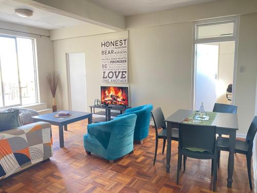 a living room with a table and chairs and a fireplace at Luyindalo Accomodation at Granten Heights in Summerstrand