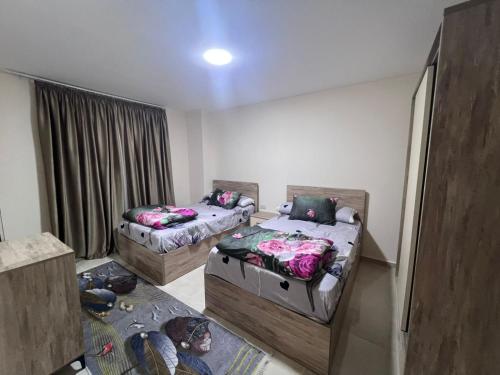 a room with two beds and a window at Tiba Golden Resort in Hurghada