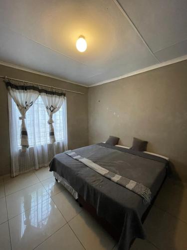 a bedroom with a bed and a window at Mbombela Stay in Nelspruit