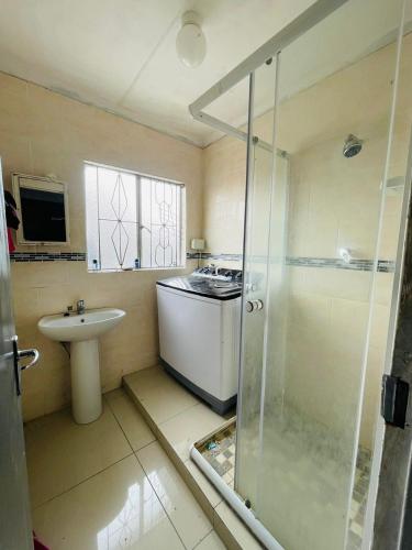 a bathroom with a shower and a sink and a stove at Mbombela Stay in Nelspruit