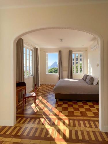 a bedroom with a bed and a desk and windows at Casa Rocha in Rio de Janeiro