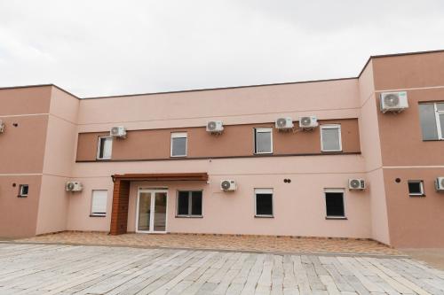 a large pink building with windows at Gallus Inn in Aleksinac